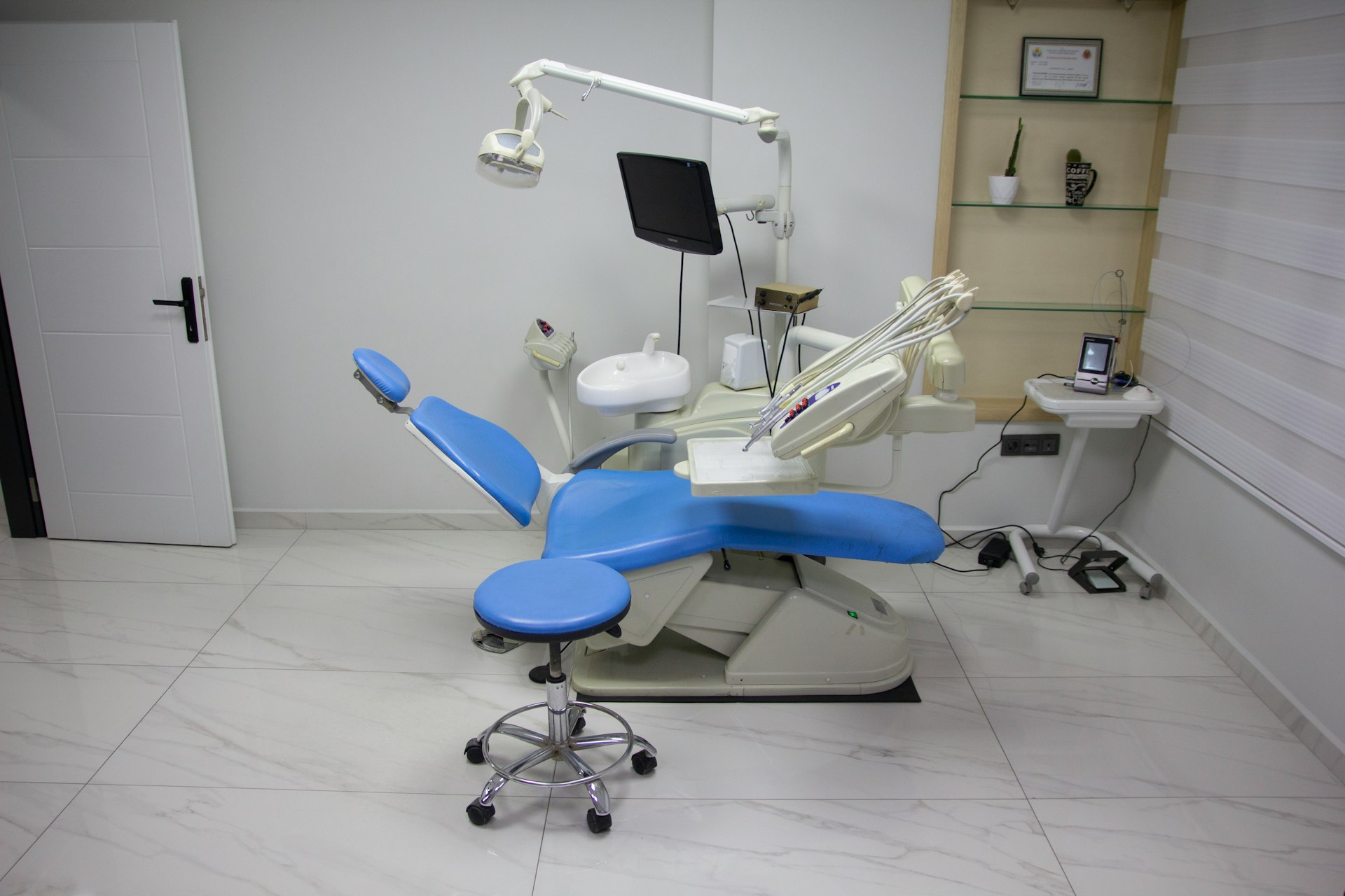 a dentist chair with a blue seat in a room